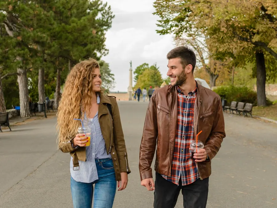 Imagen referencial: pareja conversando mientras camina por un parque