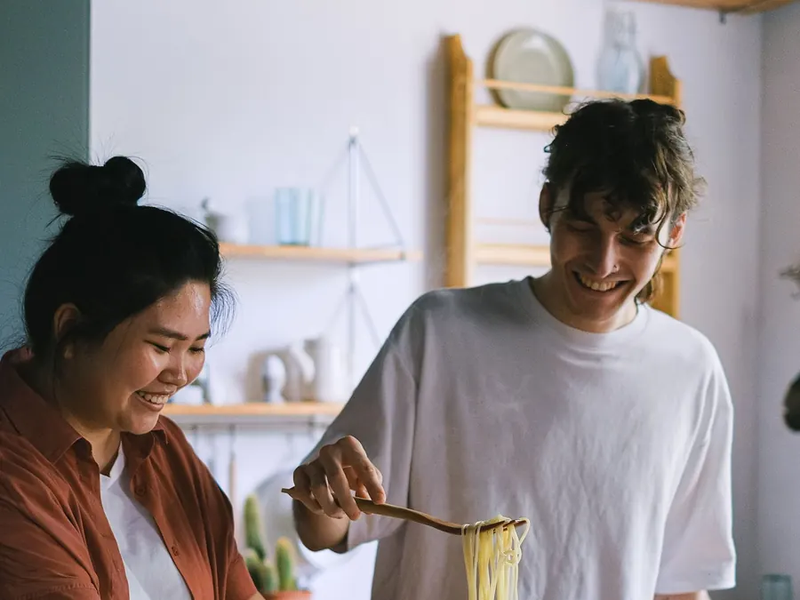 Imagen referencial: pareja cocinando y riendo en su cocina